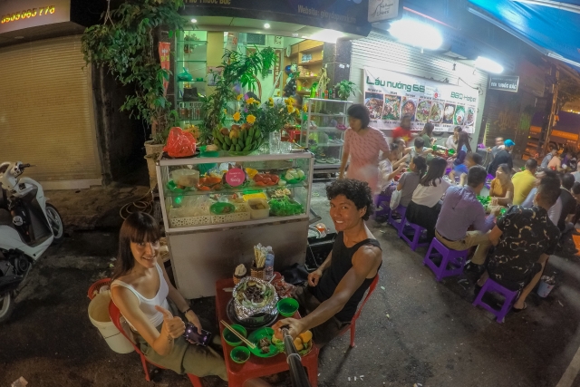 couple having dinner in a street restaurant in Hanoi city